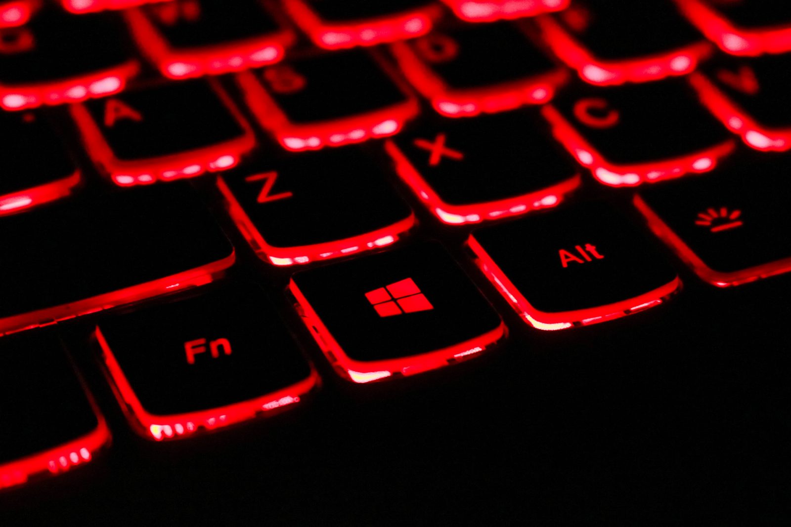 Tietokoneen musta näppäimistö, jossa on punaiset valot