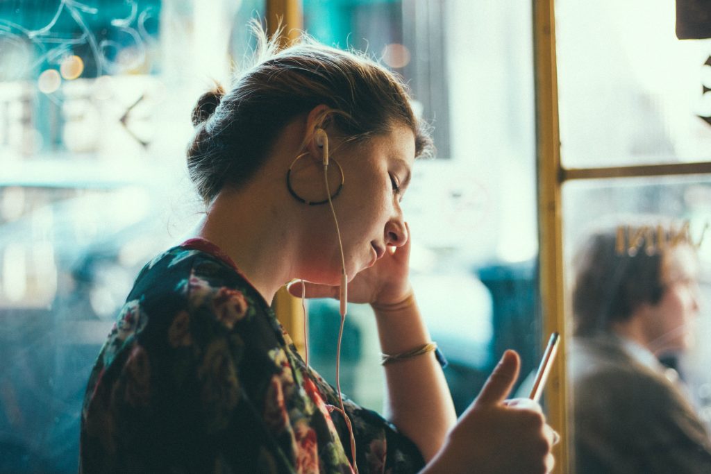 Woman listening something pfrom her phone with headphones.